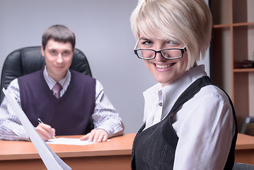 Image showing Young and smiling business lady in office