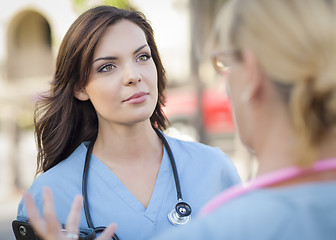 Image showing Two Young Adult Female Doctors or Nurses Talking Outside