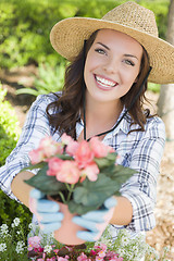 Image showing Young Adult Woman Wearing Hat Gardening Outdoors