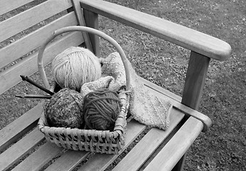Image showing Basket of knitting and yarns on a bench