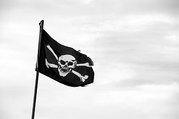 Image showing Torn Jolly Roger flies from flagpole