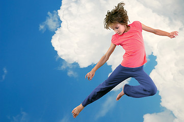 Image showing cute young dancer girl jumping against bue sky