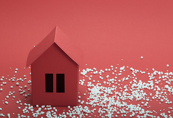 Image showing paper house in snow on red background