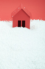 Image showing paper house in snow on red background