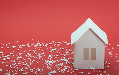 Image showing paper house in snow on red background