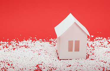 Image showing paper house in snow on red background