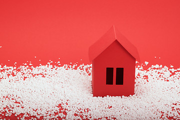 Image showing paper house in snow on red background