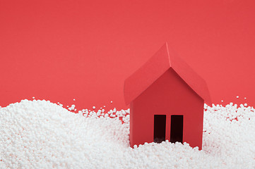 Image showing paper house in snow on red background