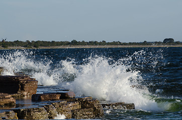 Image showing Flat rock coast with splashing water