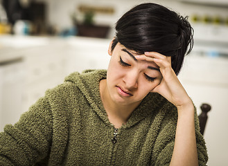 Image showing Depressed Mixed Race Young Woman Sitting Alone In Kitchen