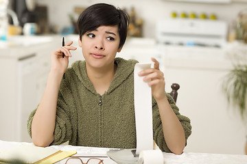 Image showing Multi-ethnic Young Woman Agonizing Over Financial Calculations