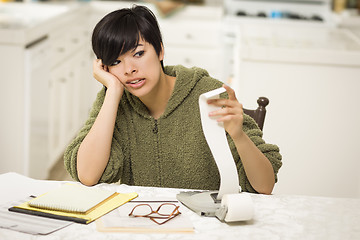 Image showing Multi-ethnic Young Woman Agonizing Over Financial Calculations