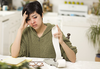 Image showing Multi-ethnic Young Woman Agonizing Over Financial Calculations