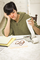 Image showing Multi-ethnic Young Woman Agonizing Over Financial Calculations