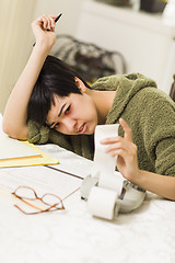 Image showing Multi-ethnic Young Woman Agonizing Over Financial Calculations