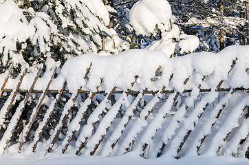 Image showing The wooden fence filled up by a snow in a countryside.