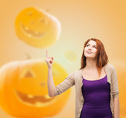 Image showing smiling teenage girl pointing finger up