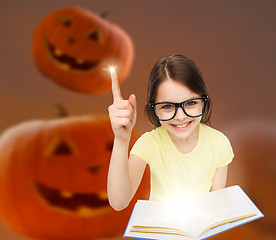 Image showing smiling girl in glasses over pumpkins background