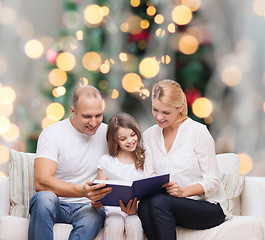 Image showing happy family with book at home