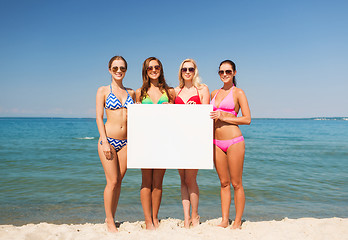 Image showing group of smiling women with blank board on beach