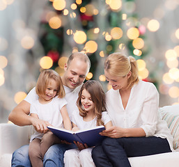 Image showing happy family with book at home