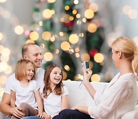 Image showing happy family with camera at home