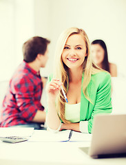 Image showing smiling student girl with laptop at school