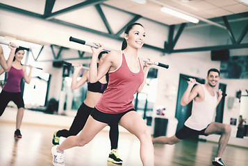 Image showing group of smiling people working out with barbells