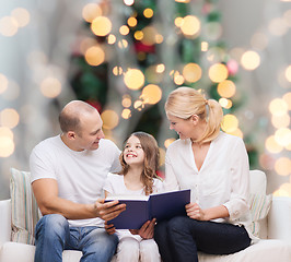 Image showing happy family with book at home