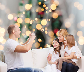 Image showing happy family with camera at home