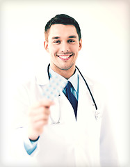 Image showing young male doctor with pack of pills