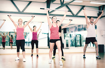 Image showing group of smiling people working out with barbells