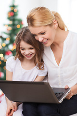 Image showing smiling mother and little girl laptop computer