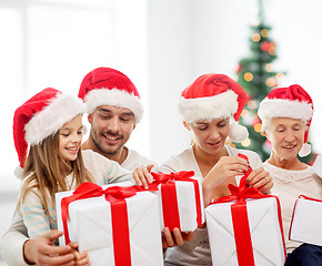 Image showing happy family in santa helper hats with gift boxes