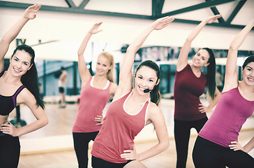 Image showing group of smiling people stretching in the gym