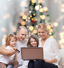 Image showing happy family with laptop computer and credit card