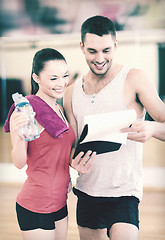 Image showing smiling male trainer with woman in the gym