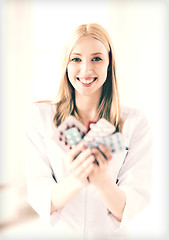 Image showing young female doctor with pack of pills