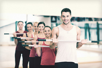 Image showing group of smiling people working out with barbells