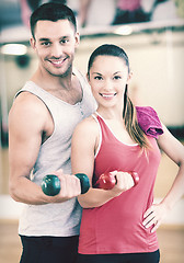 Image showing two smiling people working out with dumbbells