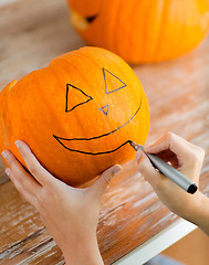 Image showing close up of woman with pumpkins at home