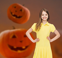 Image showing smiling girl in dress over pumpkins background
