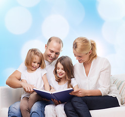 Image showing happy family with book at home