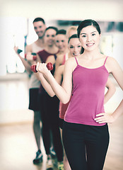 Image showing group of smiling people with dumbbells in the gym