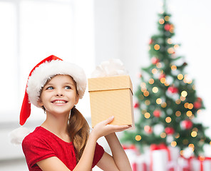 Image showing smiling girl in santa helper hat with gift box