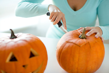 Image showing close up of woman with pumpkins at home