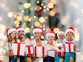 Image showing happy family in santa helper hats with gift boxes