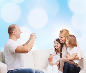 Image showing happy family with camera at home