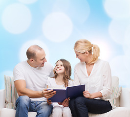 Image showing happy family with book at home