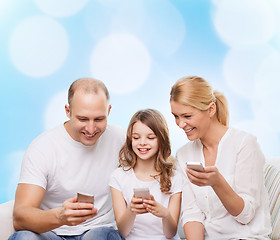 Image showing happy family with smartphones